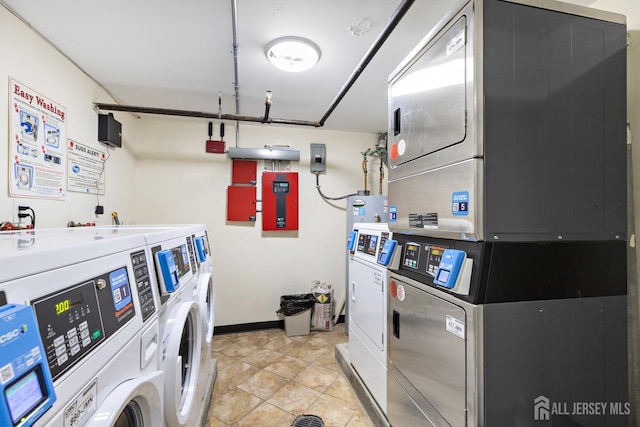 shared laundry area with light tile patterned floors, electric panel, washer and dryer, and stacked washer / dryer