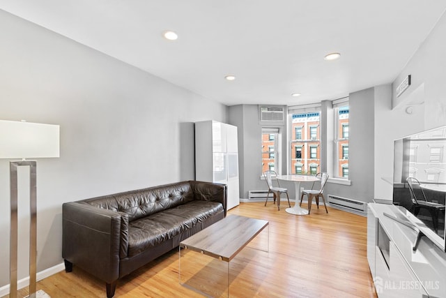 living room featuring light wood finished floors, baseboards, an AC wall unit, and recessed lighting