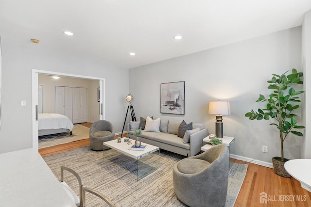 living area with recessed lighting, wood finished floors, and baseboards