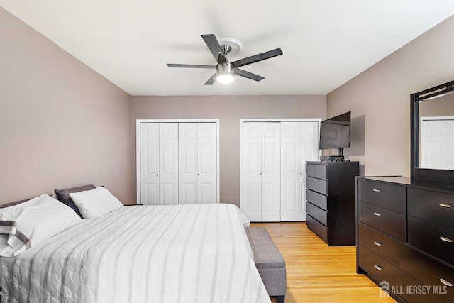 bedroom with multiple closets, light wood-style floors, and a ceiling fan