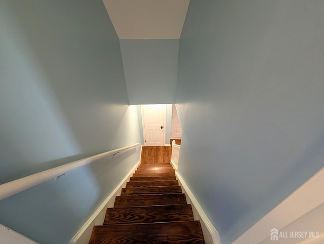 stairway with baseboards and wood finished floors