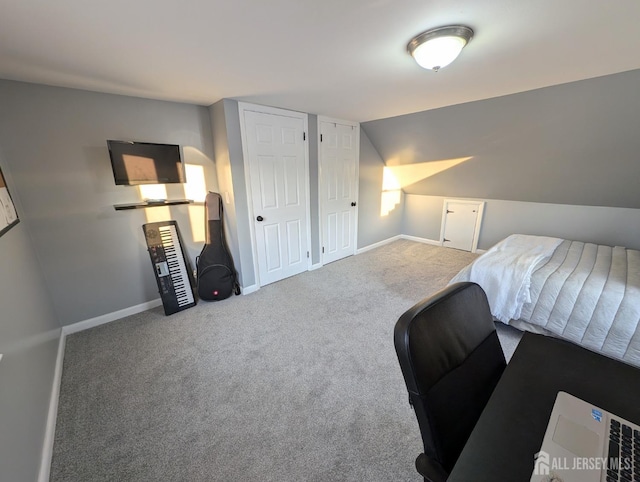 bedroom with multiple closets, baseboards, vaulted ceiling, and carpet flooring