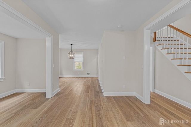 307 Wayne St, Highland Park, NJ 08904 - spare room featuring wood finished floors, stairs, and a chandelier