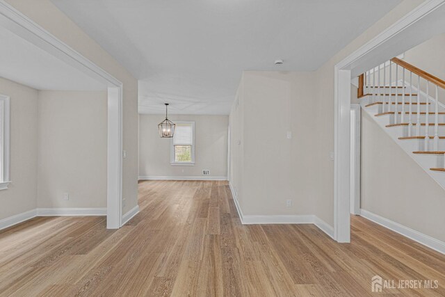 307 Wayne St, Highland Park, NJ 08904 - spare room featuring wood finished floors, stairs, and a chandelier