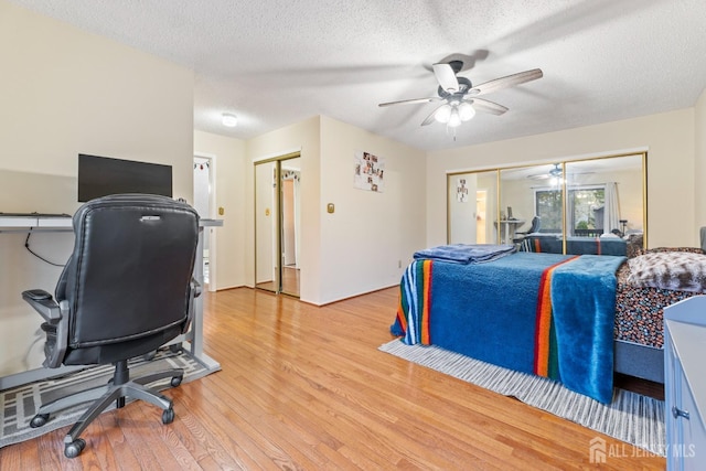 bedroom with a closet, light wood finished floors, a textured ceiling, and a ceiling fan