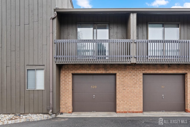 multi unit property with a garage and brick siding