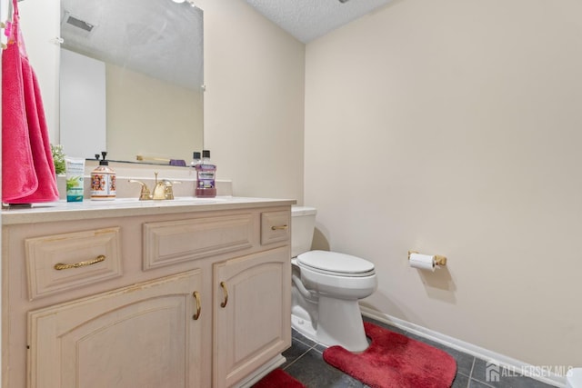 bathroom featuring toilet, vanity, baseboards, and visible vents