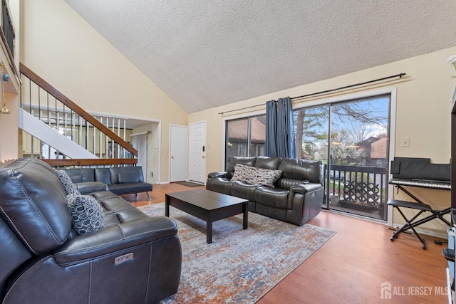 living room featuring stairway, wood finished floors, and a textured ceiling
