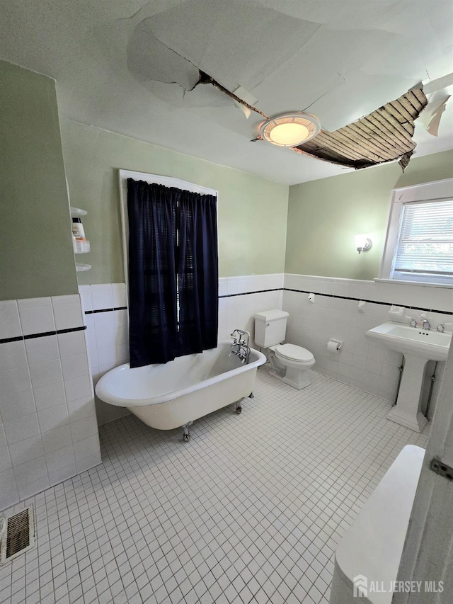 237 Prospect Ave, Dunellen, NJ 08812 - full bathroom with tile walls, a wainscoted wall, a freestanding bath, and tile patterned floors