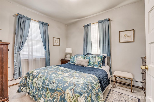 bedroom featuring a baseboard radiator, multiple windows, and carpet floors