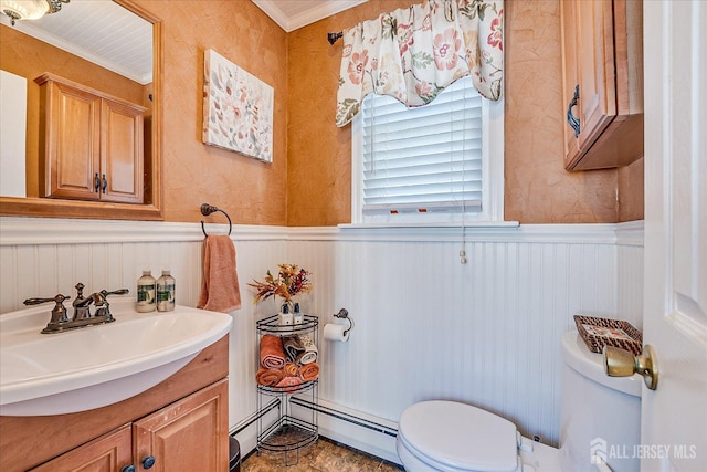 bathroom with crown molding, a wainscoted wall, toilet, vanity, and a baseboard radiator