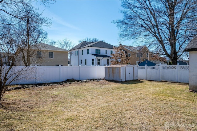 view of yard featuring an outbuilding, a storage unit, and a fenced backyard