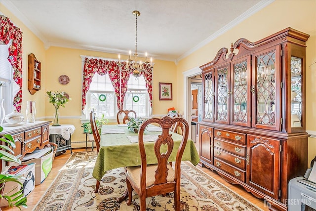 dining room with light wood-type flooring, a chandelier, and ornamental molding