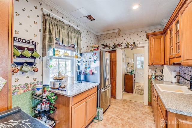 kitchen with glass insert cabinets, ornamental molding, freestanding refrigerator, and a sink