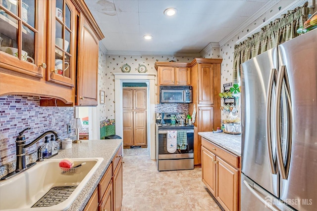 kitchen featuring a sink, appliances with stainless steel finishes, ornamental molding, and wallpapered walls