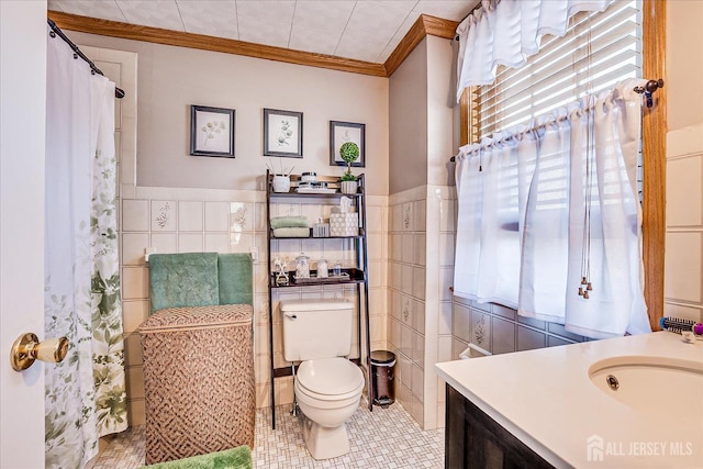 full bath featuring vanity, tile walls, toilet, and crown molding