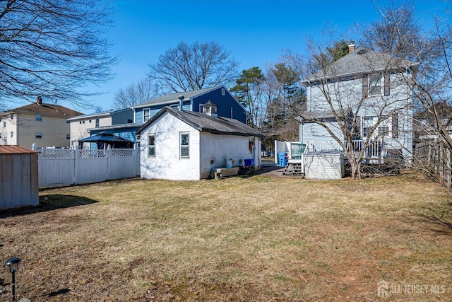 rear view of house with an outdoor structure, a yard, a fenced backyard, and a shed