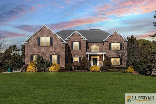 view of front of house featuring brick siding and a front lawn