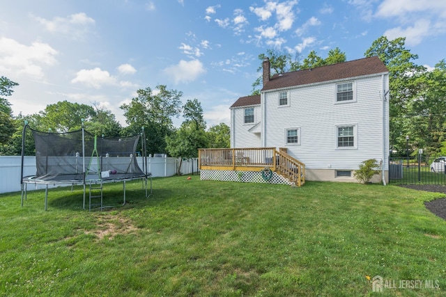 324 Greene Ave, Middlesex, NJ 08846 - back of property with a trampoline, a fenced backyard, a wooden deck, and a chimney