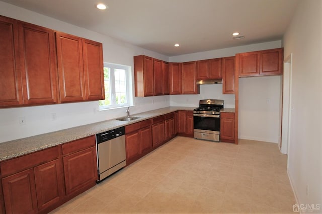 kitchen with light stone countertops, sink, and appliances with stainless steel finishes