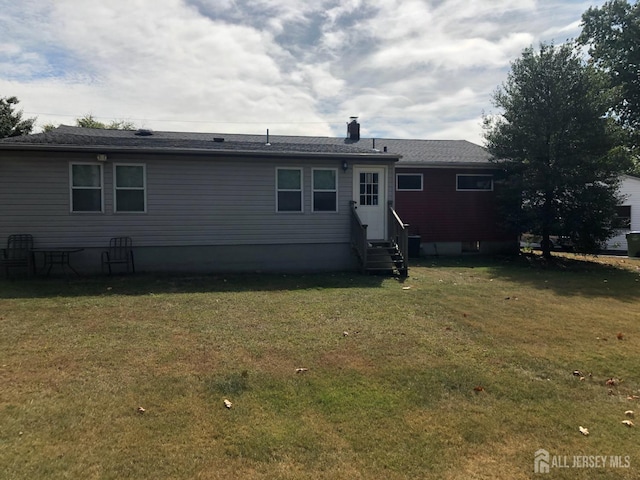 rear view of property featuring a lawn