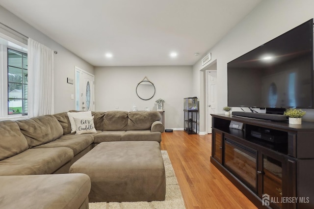 living room featuring recessed lighting, light wood finished floors, and baseboards