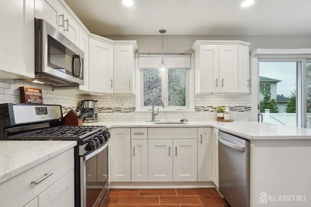 kitchen featuring stainless steel appliances, recessed lighting, white cabinetry, and a sink