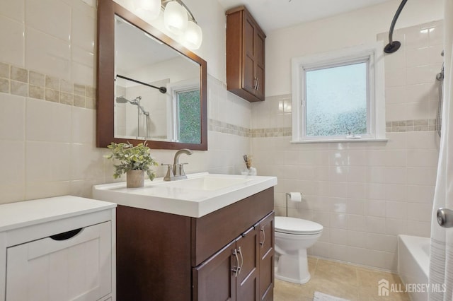 bathroom with tile patterned floors, vanity, tile walls, and toilet