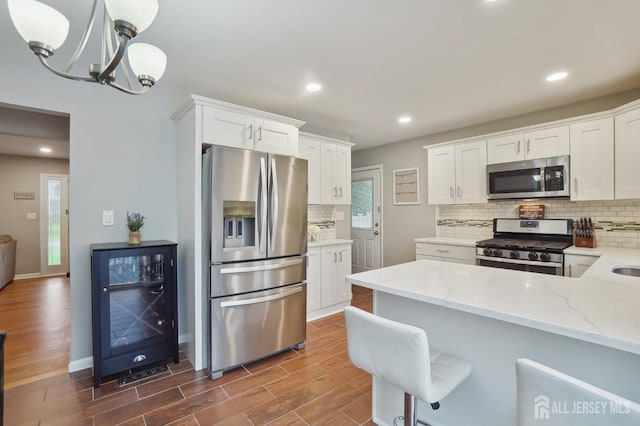 kitchen featuring tasteful backsplash, dark wood-style floors, white cabinets, appliances with stainless steel finishes, and beverage cooler