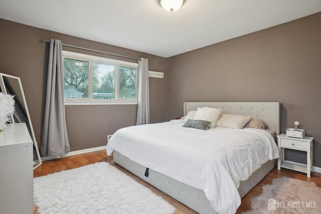 bedroom with baseboards and wood finished floors