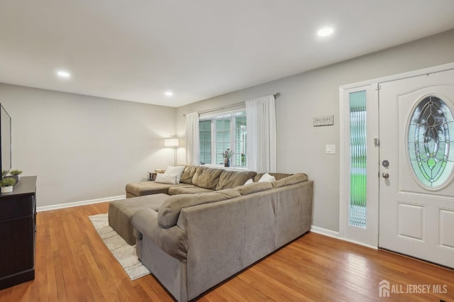 living room with baseboards, recessed lighting, and light wood-style floors