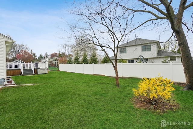 view of yard featuring a wooden deck and fence