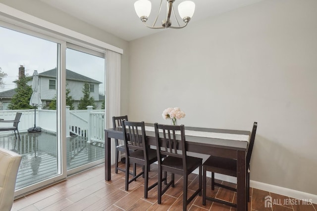 dining area featuring wood finished floors, an inviting chandelier, and baseboards