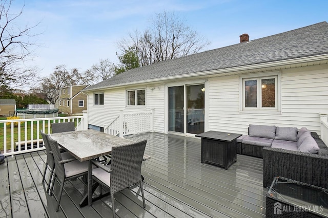 wooden terrace with an outdoor living space and outdoor dining space