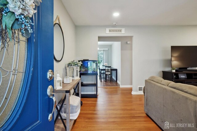 entryway with recessed lighting, visible vents, baseboards, and wood finished floors