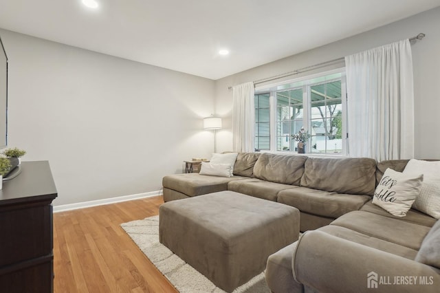 living room featuring light wood-style flooring, baseboards, and recessed lighting