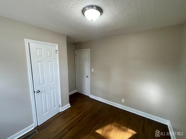 520 Hayward St, Bound Brook, NJ 08805 - unfurnished room featuring dark wood-type flooring, baseboards, and a textured ceiling