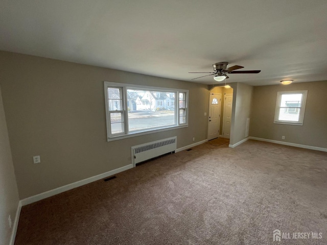 520 Hayward St, Bound Brook, NJ 08805 - unfurnished living room featuring radiator heating unit, a ceiling fan, baseboards, and carpet