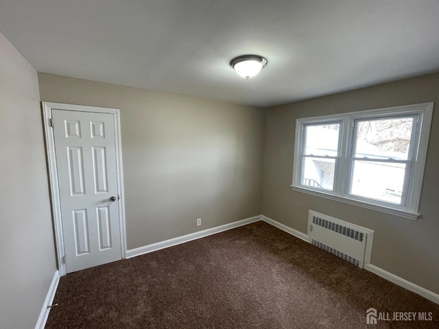 520 Hayward St, Bound Brook, NJ 08805 - unfurnished room with radiator, dark colored carpet, and baseboards