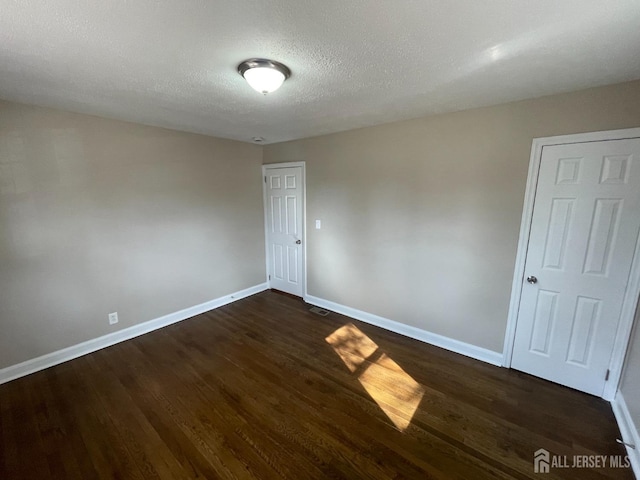 520 Hayward St, Bound Brook, NJ 08805 - empty room with baseboards, dark wood-type flooring, and a textured ceiling
