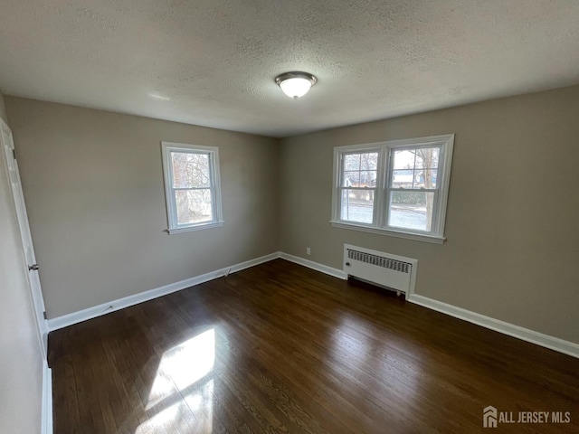 520 Hayward St, Bound Brook, NJ 08805 - unfurnished room with radiator, a textured ceiling, dark wood finished floors, and baseboards