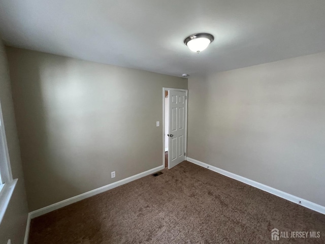 520 Hayward St, Bound Brook, NJ 08805 - empty room featuring dark colored carpet and baseboards