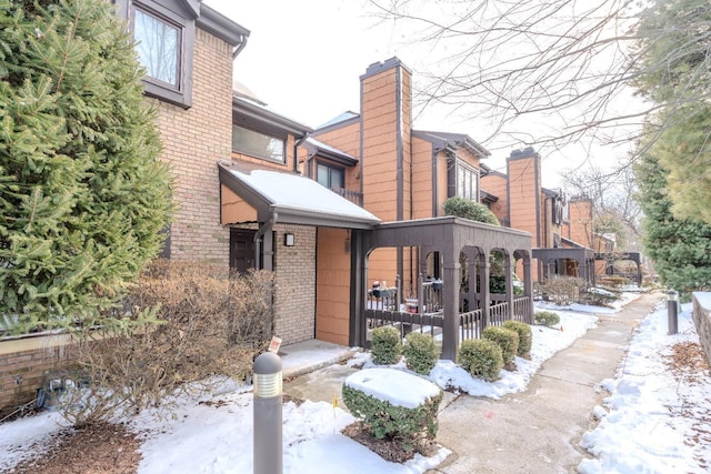 exterior space featuring a chimney, a porch, and brick siding