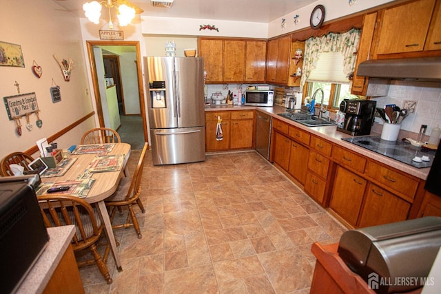 282 Bridgepoint Rd, Montgomery, NJ 08502 - kitchen featuring stainless steel appliances, under cabinet range hood, brown cabinetry, light countertops, and backsplash