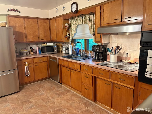 kitchen featuring stainless steel appliances, a sink, under cabinet range hood, brown cabinets, and light countertops