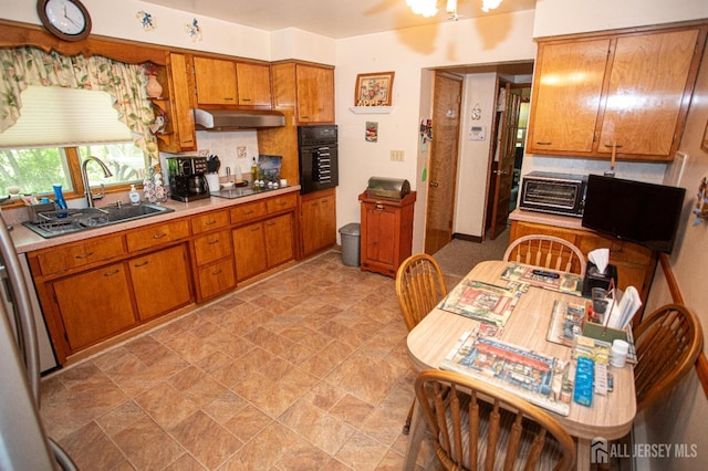 282 Bridgepoint Rd, Montgomery, NJ 08502 - kitchen featuring black appliances, under cabinet range hood, brown cabinets, light countertops, and backsplash