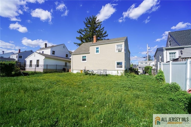 rear view of property featuring fence and a chimney
