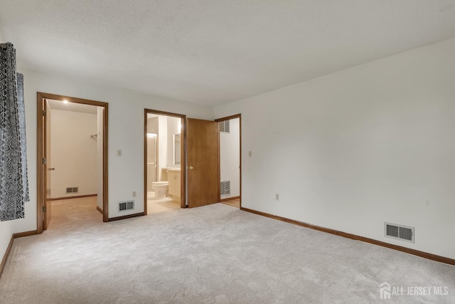 352 Lancaster Ct, Piscataway, NJ 08854 - unfurnished bedroom featuring light colored carpet, baseboards, ensuite bathroom, and a textured ceiling