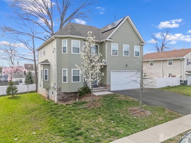 767 Coolidge Ave, Woodbridge Proper, NJ 07095 - view of front of property featuring asphalt driveway, an attached garage, roof mounted solar panels, and a shingled roof