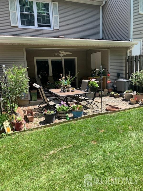 exterior space featuring a lawn, ceiling fan, cooling unit, and a patio